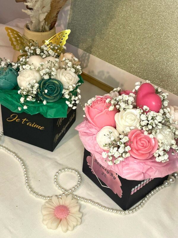 Bouquet personnalisable en cire avec fleurs roses, blanches et vertes, présenté dans une boîte noire décorative avec du gypsophile.
